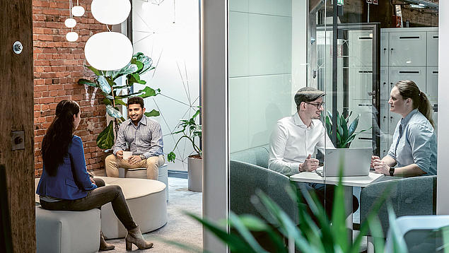 Beratungssituation bei der HHLA: Mitarbeitende besprechen Fördermittel und Investitionsvorhaben in einem modernen Besprechungsraum.