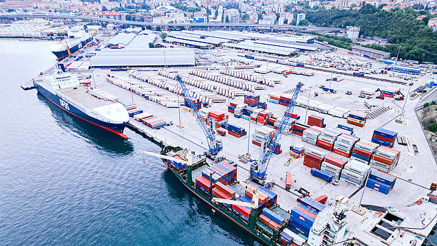 Luftaufnahme des HHLA Seehafenterminals PLT Italy in Triest – Mehrzweck-Terminal für Containerumschlag, RoRo und Stückgut mit Bahnanbindung.