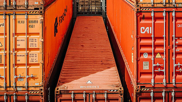Mehrere orange- und braune Container aufeinandergestapelt.