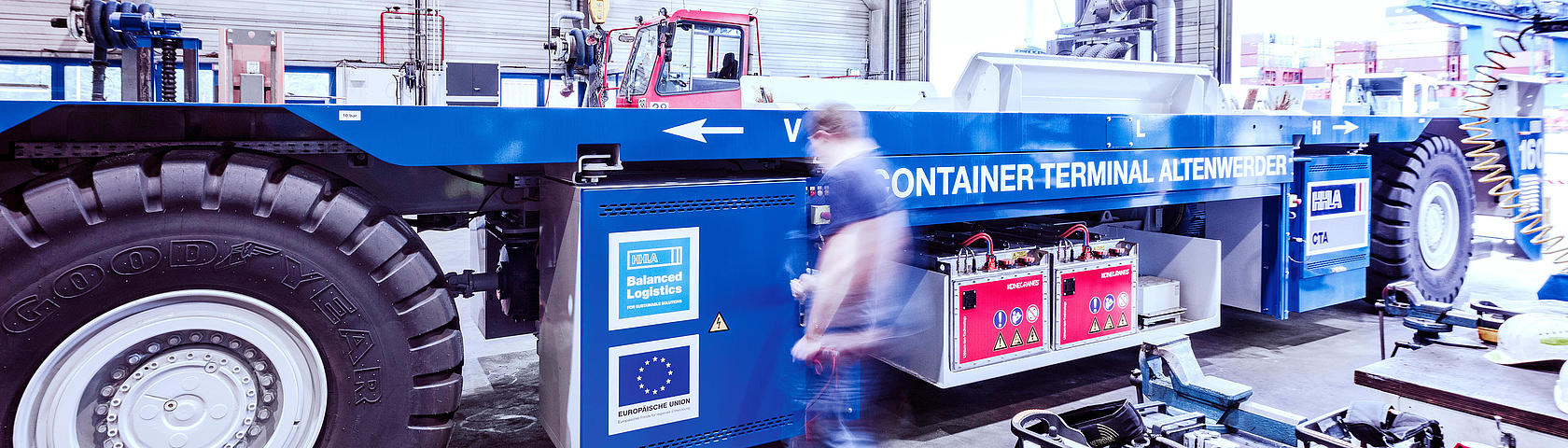 Mitarbeiter wartet ein automatisiertes Transportfahrzeug (AGV) in der Werkstatt des HHLA Container Terminals Altenwerder in Hamburg.